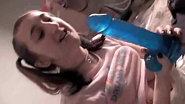 Teenager in a diaper sucks on blue dildo